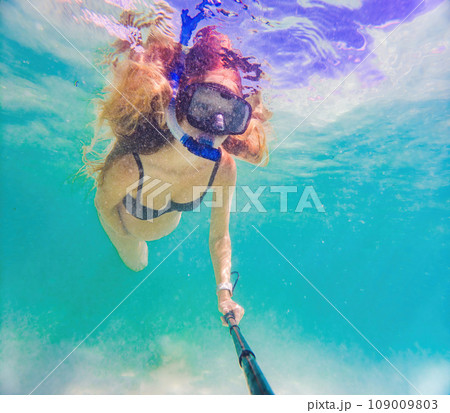 In an ethereal underwater scene, a pregnant woman gracefully floats, embodying the beauty of maternity beneath the tranquil surface of the sea 109009803