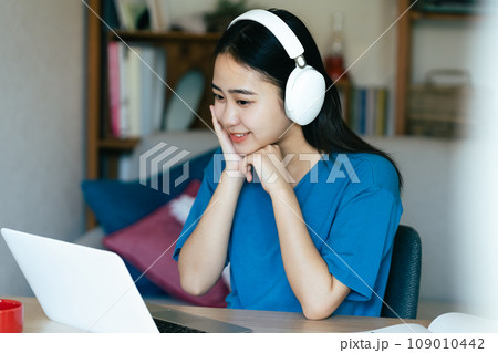 リビングで外国語学習をする若い女性 リビングで外国語学習をする若い女性 109010442