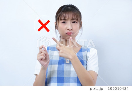 バツのプレートを持つエプロン姿の女性イメージ バツのプレートを持つエプロン姿の女性イメージ 109010484