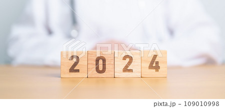 Doctor hand flipping 2023 to 2024 block. Happy New Year for Medical, Health care, Insurance and Wellness concepts 109010998