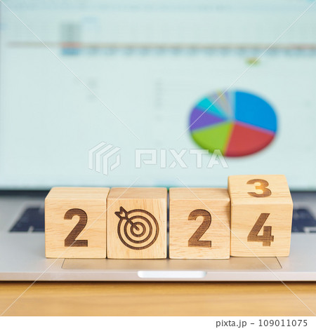 2024 Year block with dartboard icon against computer laptop background. Goal, Target, Resolution, strategy, plan, Action, mission, motivation, and New Year start concepts 109011075