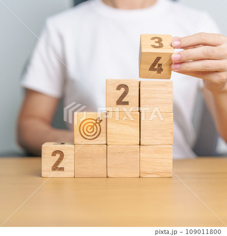 2024 wood block dartboard sign with Building. business goal, success, strategy, target, mission, action, growth, teamwork, plan, idea and New Year start concept 109011800