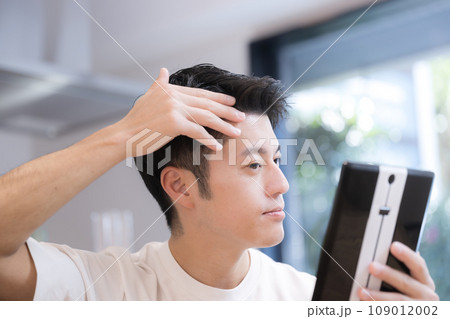 髪の生え際を気にする若い男性 109012002