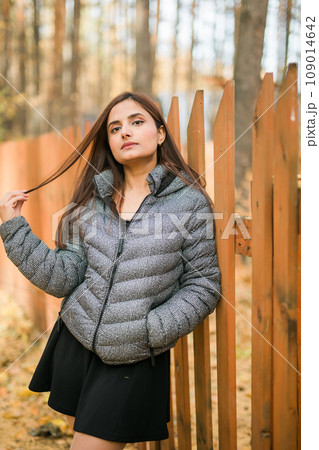 Close up portrait of pretty indian young woman enjoying warm autumn sunny day vacation outdoors. Generation z and gen z concept. Fall Season Close up portrait of pretty indian young woman enjoying warm autumn sunny day vacation outdoors. Generation z and gen z concept. Fall Season 109014642