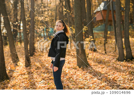 Outdoor atmospheric lifestyle portrait of young beautiful young woman copy space. Warm autumn fall season. Millennial generation and youth 109014696