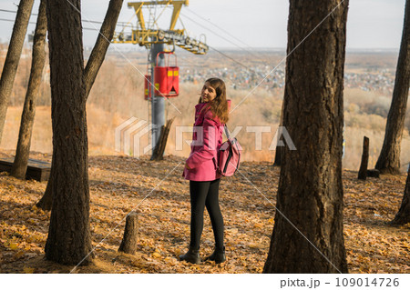Back view of a girl walking on autumn park in fall season. Generation Z and gen z youth. Copy empty space for text. Back view of a girl walking on autumn park in fall season. Generation Z and gen z youth. Copy empty space for text. 109014726