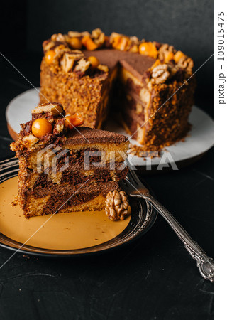 Piece of homemade cake with white cream on a gray background. Festive dessert concept. Piece of homemade cake with white cream on a gray background. Festive dessert concept. 109015475