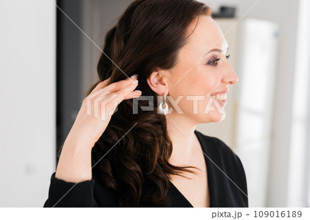 Detail of young woman wearing beautiful luxury earring. Handmade jewellery and accessories Detail of young woman wearing beautiful luxury earring. Handmade jewellery and accessories 109016189