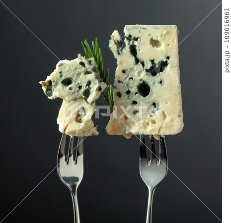Blue cheese slices on forks. 109016961