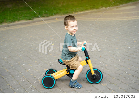 A cute toddler boy of two or three years old rides a bicycle or balance bike in a city park on a sunny summer day. Toddlerhood and childhood concept. Selective focus A cute toddler boy of two or three years old rides a bicycle or balance bike in a city park on a sunny summer day. Toddlerhood and childhood concept. Selective focus 109017003