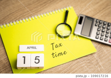 15 april - tax time concept. Taxpaying, business and finance. Notes, magnifying glass and calculator 15 april - tax time concept. Taxpaying, business and finance. Notes, magnifying glass and calculator 109017216