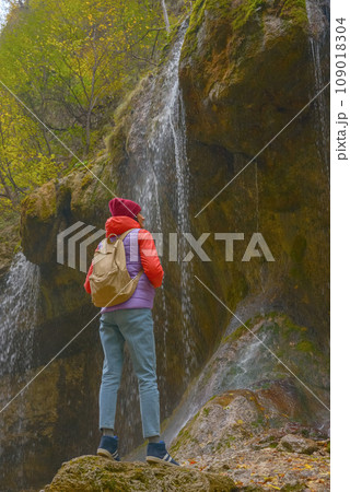 Travel. The girl travels through the mountains and waterfalls of the wild. Unity, mental health, eco-travel. Hiking, traveling, good times, digital detox. 109018304
