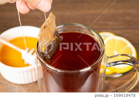 Preparation tea from a tea bag in a glass cup. 109018478