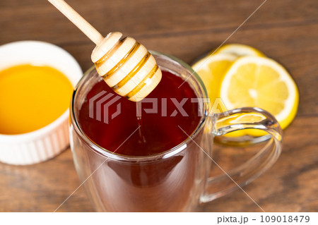 Adding honey to black tea, making vitamin healthy tea. 109018479