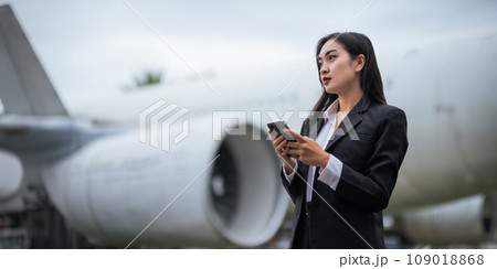 Successful business woman still traveling to work talking on mobile In the middle of the airport Successful business woman still traveling to work talking on mobile In the middle of the airport 109018868