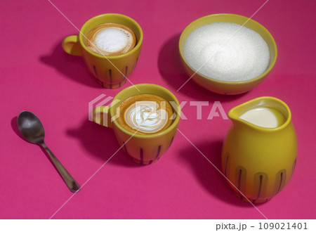 Latte mugs on hot pink background, yellow and white 109021401