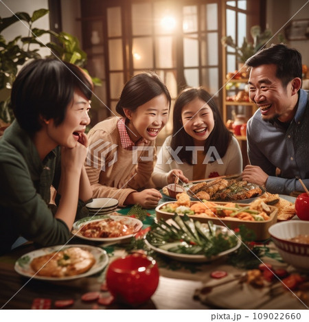 A family gathered around a table, enjoying a traditional Chinese New Year feast featuring dumplings A family gathered around a table, enjoying a traditional Chinese New Year feast featuring dumplings 109022660