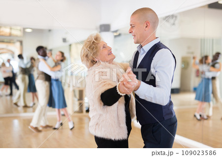 Man and mature woman learning to dance classical ballroom dance Man and mature woman learning to dance classical ballroom dance 109023586