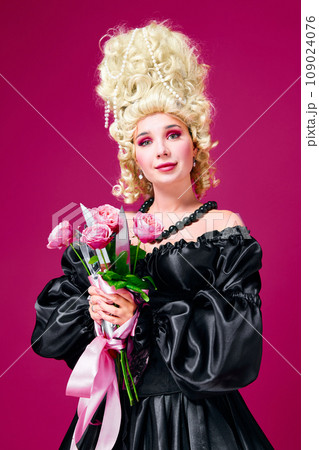 Hidden revenge. Portrait of queen young lady holding bunch of flowers with sharp knives against magenta background. 109024076
