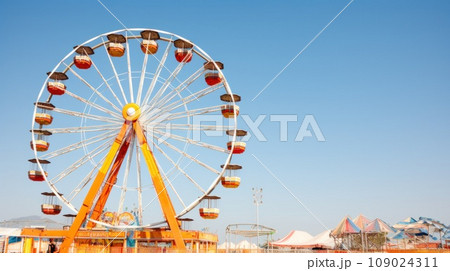 A towering Ferris wheel serves as the focal point of this carnival-themed A towering Ferris wheel serves as the focal point of this carnival-themed 109024311