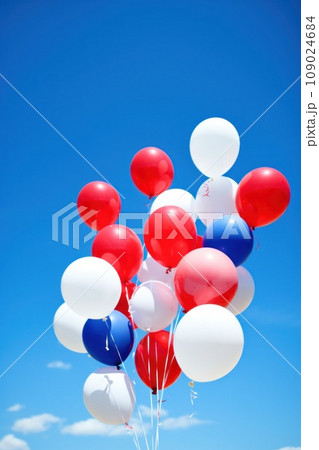 balloons in patriotic colors floating against a bright blue sky 109024684