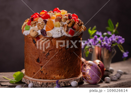 Easter Cake with dried fruits and nuts on a wooden table. Delicious traditional bakery and painted eggs for the main orthodox holiday. Easter Cake with dried fruits and nuts on a wooden table. Delicious traditional bakery and painted eggs for the main orthodox holiday. 109026614