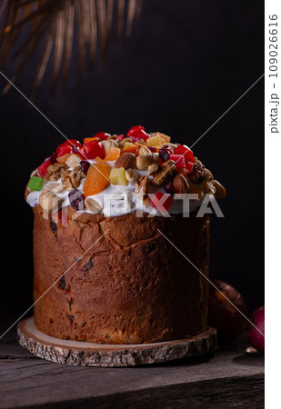 Easter Cake with dried fruits and nuts on a wooden table. Delicious traditional bakery and painted eggs for the main orthodox holiday. Easter Cake with dried fruits and nuts on a wooden table. Delicious traditional bakery and painted eggs for the main orthodox holiday. 109026616