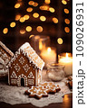 Gingerbread house on table. Defocused lights of Christmas garland. Evening in the living room. Holiday mood.  109026931