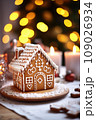 Gingerbread house on table. Defocused lights of Christmas garland. Evening in the living room. Holiday mood.  109026934