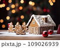 Gingerbread house on table. Defocused lights of Christmas garland. Evening in the living room. Holiday mood.  109026939