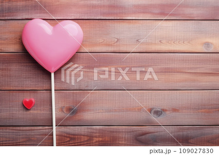 Heart shaped candy lollipop for valentines day on a wooden table. Heart shaped candy lollipop for valentines day on a wooden table. 109027830