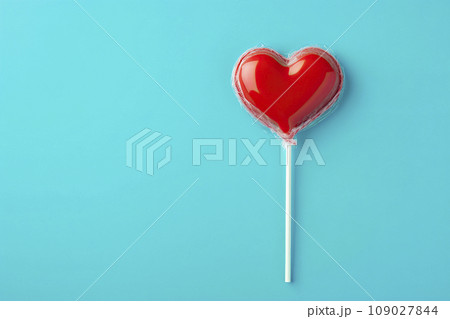 Heart shaped candy lollipop for valentines day on blue background Heart shaped candy lollipop for valentines day on blue background 109027844