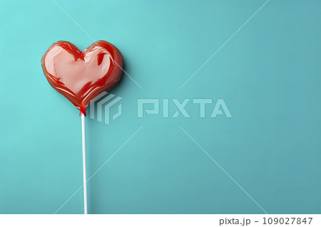 Heart shaped candy lollipop for valentines day on blue background Heart shaped candy lollipop for valentines day on blue background 109027847