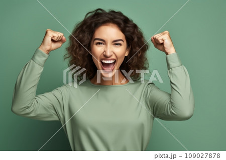 A young brown woman with curly hair who celebrates her victory A young brown woman with curly hair who celebrates her victory 109027878