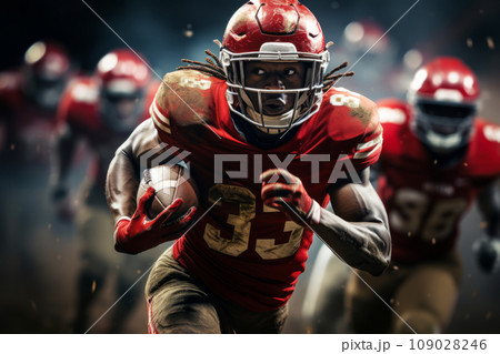 American football player of African descent in red uniform runs with the ball 109028246