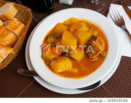 Image of appetizing tender stewed veal with sauce with potatoes and vegetables. Spanish appetizer - patatas estofadas con carne Image of appetizing tender stewed veal with sauce with potatoes and vegetables. Spanish appetizer - patatas estofadas con carne 109029198
