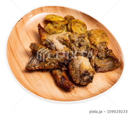 Roasted rabbit pieces with vegetable garnish of fried potatoes Roasted rabbit pieces with vegetable garnish of fried potatoes 109029233