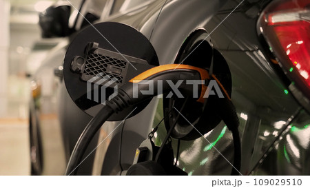 Electric Vehicle car or EV Car parking at charging station and plugged power cable supply. Charge power to EV or hybrid car battery. Green energy and eco power of World future transportation. EV power Electric Vehicle car or EV Car parking at charging station and plugged power cable supply. Charge power to EV or hybrid car battery. Green energy and eco power of World future transportation. EV power 109029510