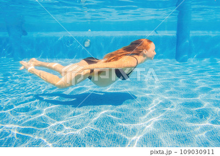 Pregnant serenity submerged a woman gracefully dives into the pool, celebrating the beauty of pregnancy with aquatic elegance Pregnant serenity submerged a woman gracefully dives into the pool, celebrating the beauty of pregnancy with aquatic elegance 109030911