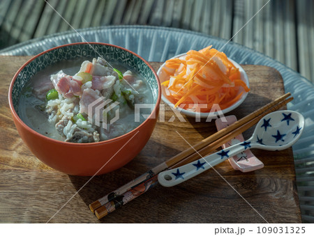 Hot Boiled rice or Rice porridge with Pork spare ribs soup and Ham served with Pickled carrot and Radish on Wooden cutting board. Hot Boiled rice or Rice porridge with Pork spare ribs soup and Ham served with Pickled carrot and Radish on Wooden cutting board. 109031325