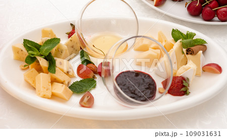 Sliced cheese on a plate with honey and sweet sauce. 109031631