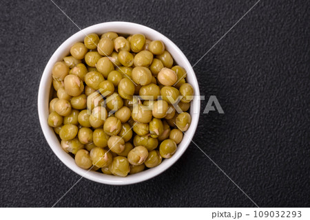 Delicious canned green peas with salt and spices in a white bowl Delicious canned green peas with salt and spices in a white bowl 109032293