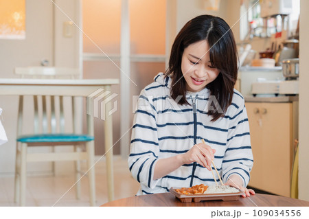 家でひとりでコンビニ弁当を食べる若い女性 家でひとりでコンビニ弁当を食べる若い女性 109034556