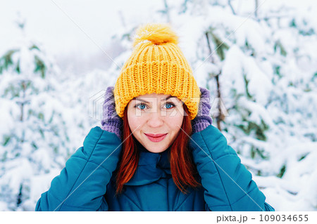 Young smiling woman enjoys snowy winter day Young smiling woman enjoys snowy winter day 109034655