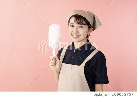 ピンクバックでハンディモップを持つハウスクリーニングの女性作業員 109035757