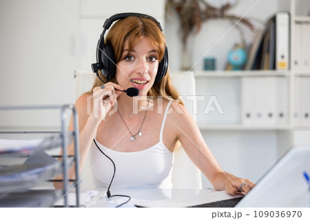 Female operator talking with customer using headset at company office 109036970