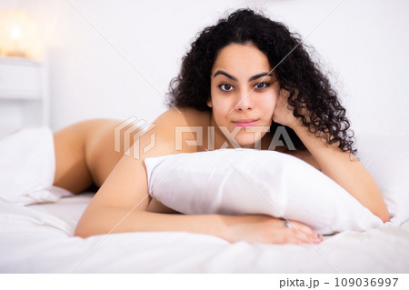 Young naked woman enjoying lying on bed Young naked woman enjoying lying on bed 109036997