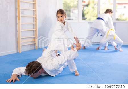 Children with parents practicing judo together on sports mats 109037250