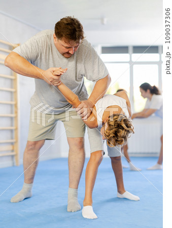 Preteen boy sparring during self-defense training with male instructor Preteen boy sparring during self-defense training with male instructor 109037306