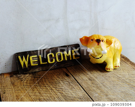 ceramic dog with welcome sign on wooden background 109039304